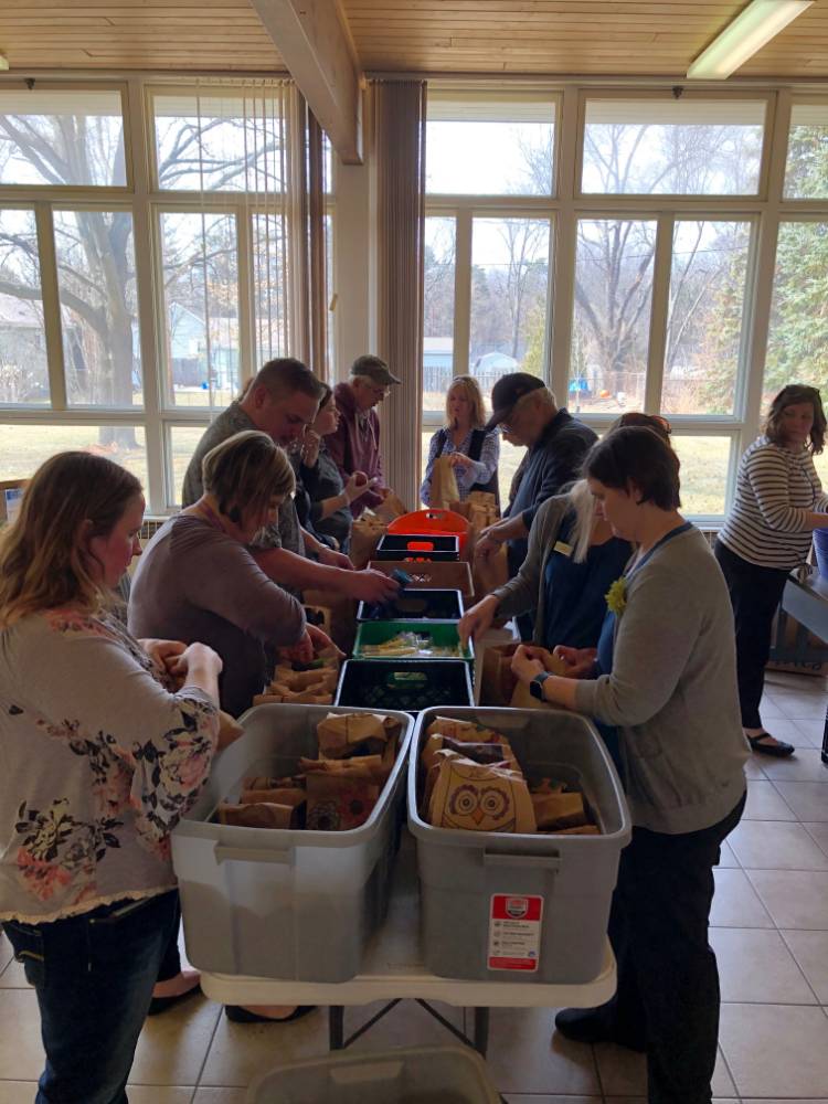 Volunteers sort food together at Kids' Food Basket in Holland.
